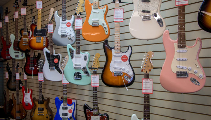 Selection of electric guitars displayed on a wall.