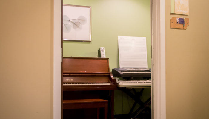 Lesson studio with a piano and two keyboards.