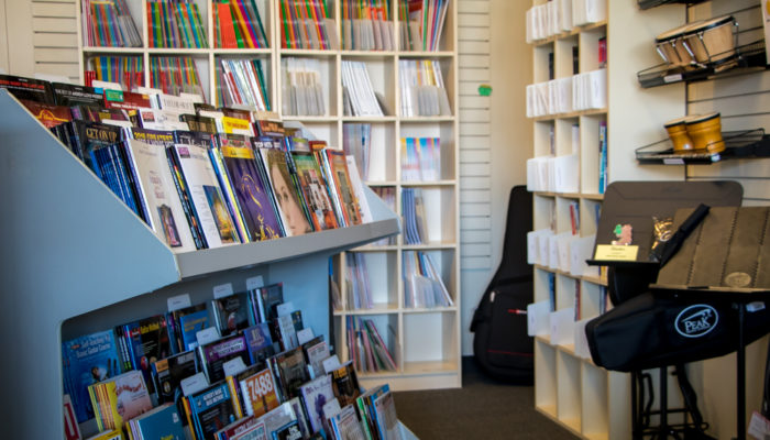 Printed music displayed on shelving.