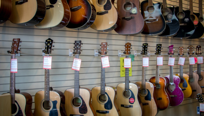 Wall display of Fender, Ibanez and Yamaha acoustic guitars.