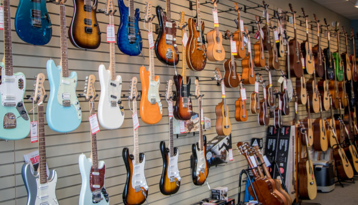 Electric guitars in many colors on wall display.