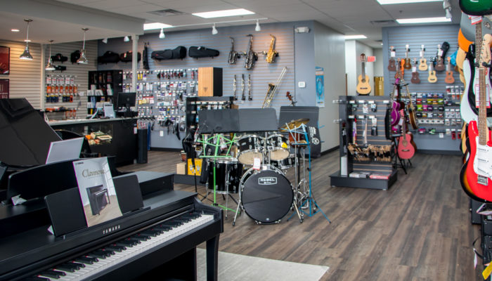 Display of Tama drumset with other musical items behind it.