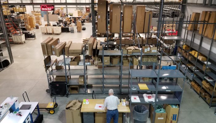 Overhead view of music instrument warehouse with man working in the forefront.