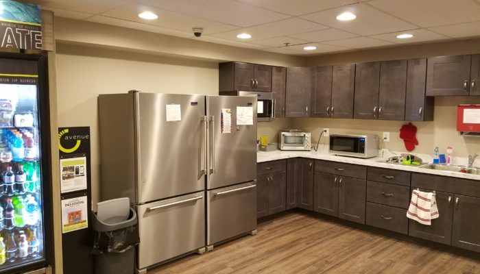 Breakroom with vending, gray cabinetry and refridgerators.