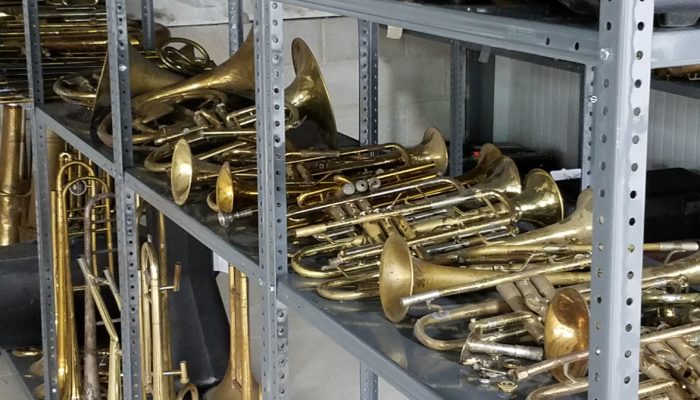 Shelves of brass instruments used for repair parts.