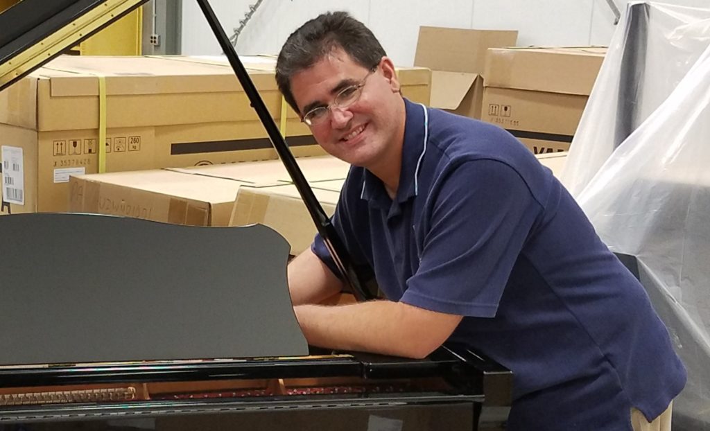 Man tuning a grand piano.