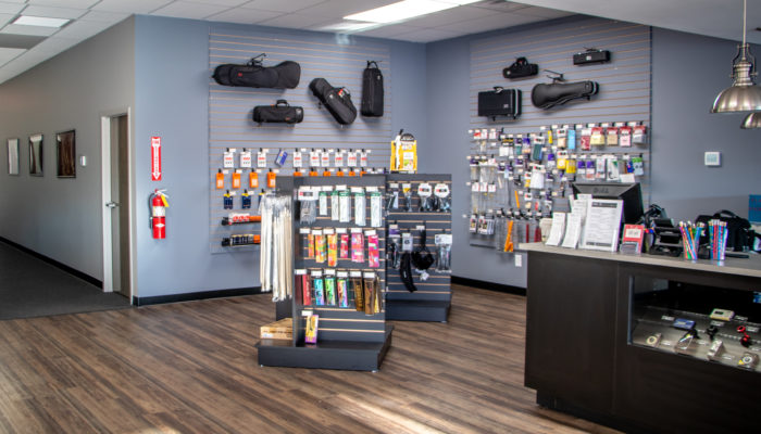 Musical accessories on small display with instrument cases hanging behind them.