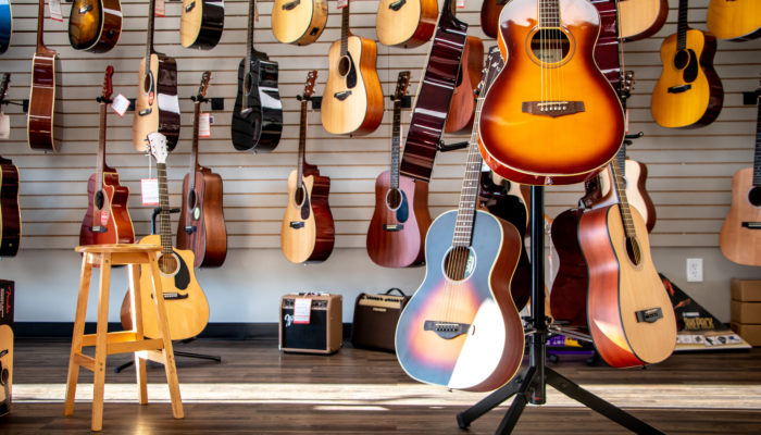 Yamaha, Ibanez and Martin acoustic guitars on floor and wall displays.