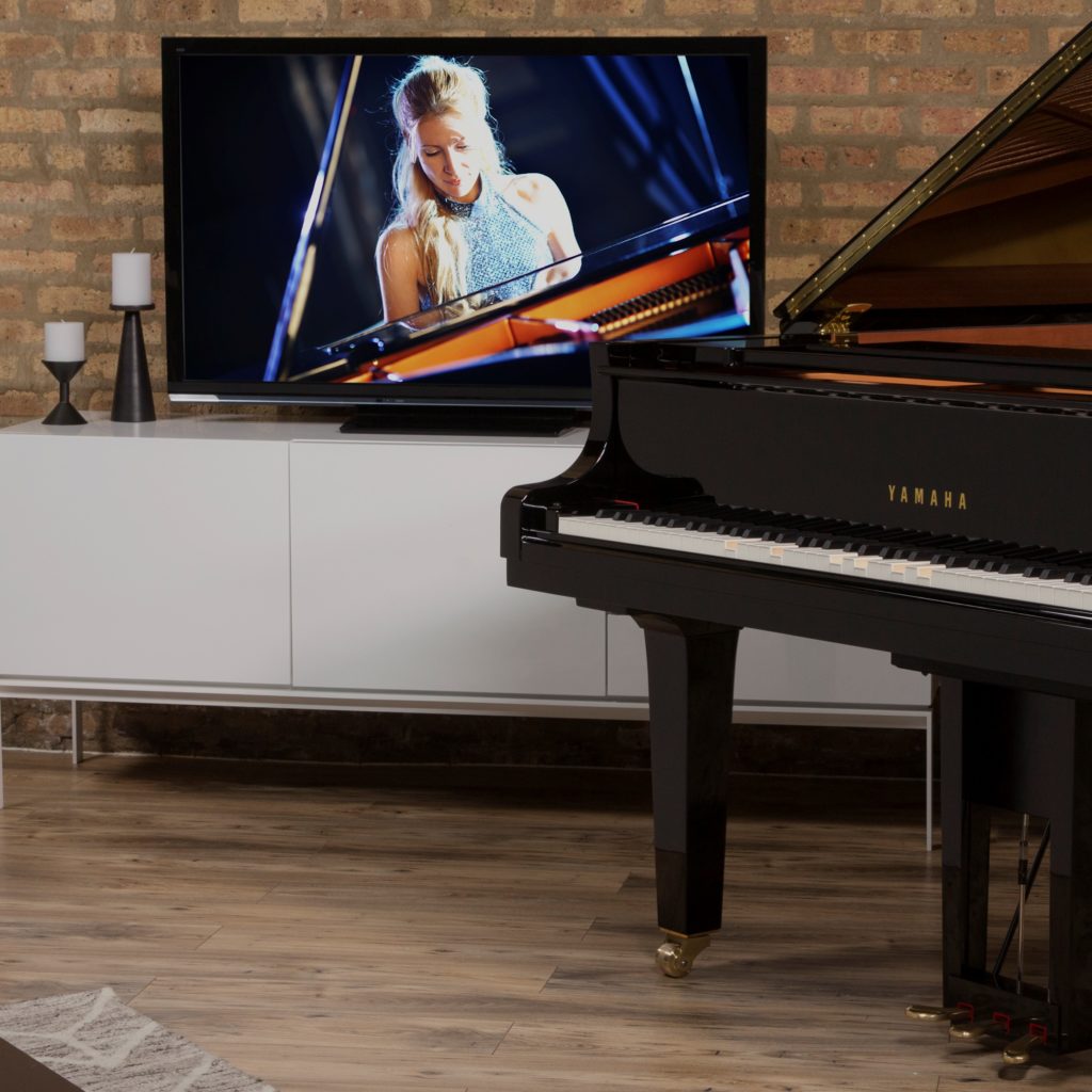 Yamaha Disklavier piano in front of television