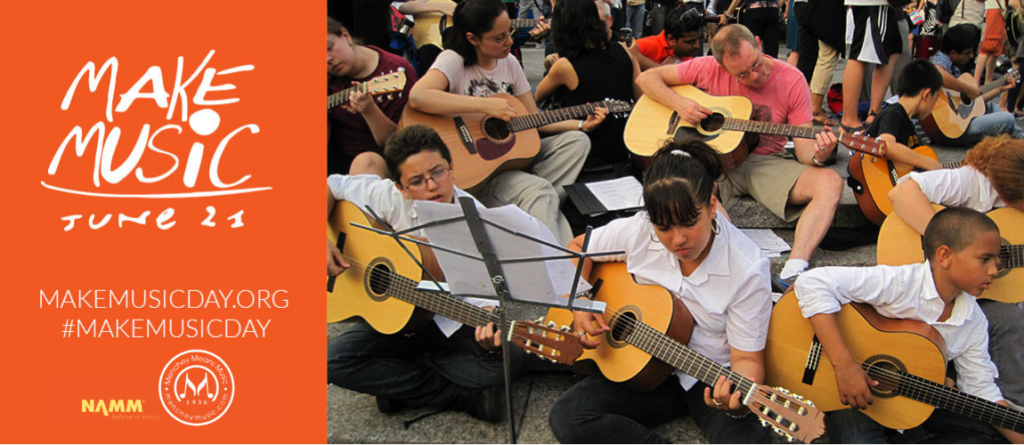 Group of people together, playing guitar on Make Music Day.