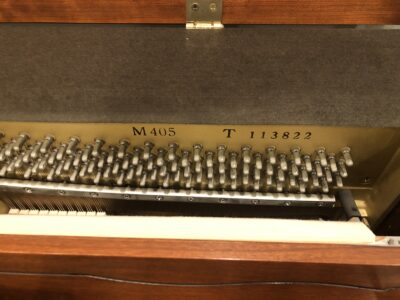 Internal view of the Yamaha M405 cherry upright to show the model number and serial number of the instrument.