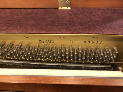 Internal view of the model and serial number of a Yamaha M405 cherry console piano(#108632)