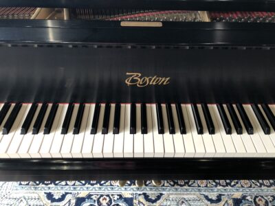 The front logo and view of the keys on a Boston GP163II satin ebony grand.