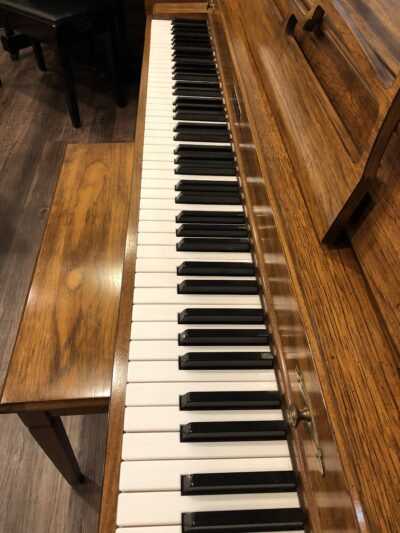 The keys of the Baldwin, model 1024, #1376388 pecan upright with matching bench.