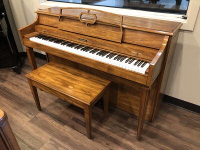 The side view of the Baldwin, model 1024, #1376388 pecan upright with matching bench.