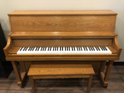 The direct front view of a Yamaha P22 in Oak, #T174979 and matching bench.