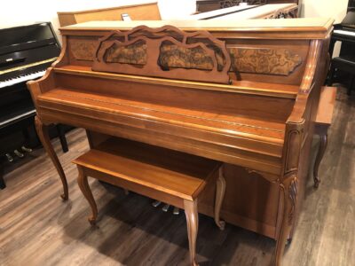The closed fallboard view of the Yamaha, Model M500P in cherry, #233143 from 1998 with matching bench.