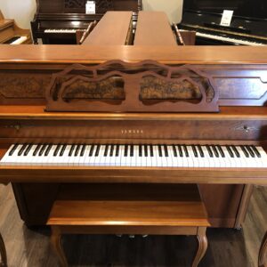The front view of a Yamaha, Model M500P in cherry, #233143 from 1998 with matching bench.