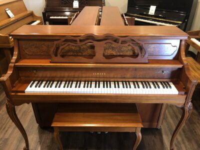 The front view of a Yamaha, Model M500P in cherry, #233143 from 1998 with matching bench.