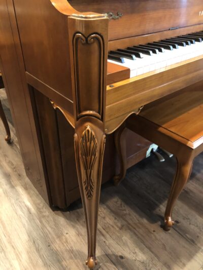 The decorative front leg of the Yamaha, Model M500P in cherry, #233143 from 1998 with matching bench.