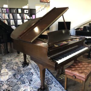 The front view of a Steinway - Model “M” (brown mahogany) – 5’7” Grand Piano with matching bench.