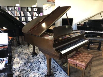 The front view of a Steinway - Model “M” (brown mahogany) – 5’7” Grand Piano with matching bench.