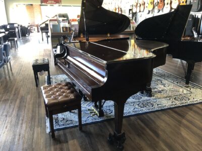 The side closed view of a Steinway - Model “M” (brown mahogany) – 5’7” Grand Piano.